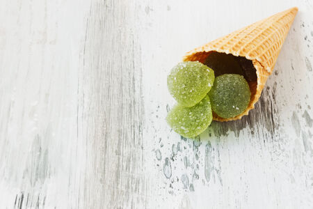 wafer cone with jelly candies  on the wooden background.の写真素材