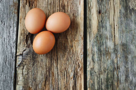 fresh brown chicken eggs on old wooden background. easter symbolsの写真素材