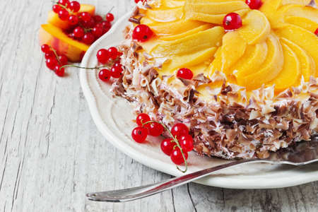 delicious cake with apricot slices and red currant on wooden background close-up. の写真素材