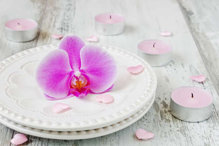 purple orchid flower in a dish on the holiday table, candles and valentine. festivals and events. selective focusの写真素材