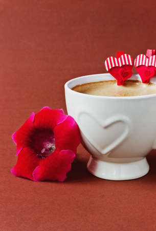 cup of coffee, flower and decorative valentine on a brown background. valentine's day. holidays and eventsの写真素材