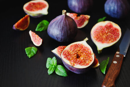 delicious fresh figs and fresh mint leaves on a black wooden background.health and diet food.selective focusの写真素材