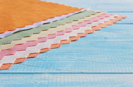 cloth napkins in different colors on a blue wooden background. backgrounds and textures. copy space...