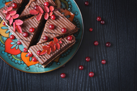 chocolate cake and ripe cranberries on a black wooden background. top view. holidays and events.の写真素材