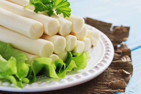 cheese sticks and lettuce on a plate on the table. cheese and dairy products