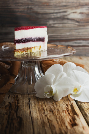 piece of cake with a cream puff on a glass base on the old wooden background. holidays and events. copy space backgroundの写真素材