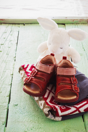 old children's clothes and toys on a green wooden backgroundの写真素材