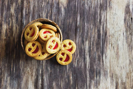 biscuits with jam in a bowl on the old wooden background. sweet pastries. top viewの写真素材