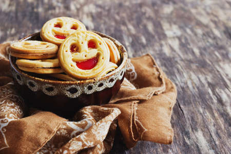 biscuits with jam in a bowl on the old wooden background. sweet pastries.