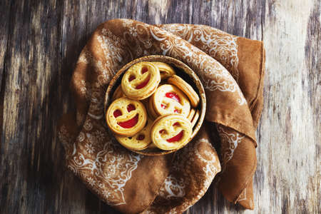 biscuits with jam in a bowl on the old wooden background. sweet pastries. top viewの写真素材