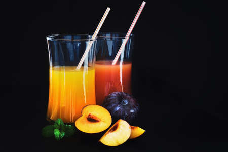 plum juice in a glass and fresh ripe plums on a black background.health and diet foodの写真素材