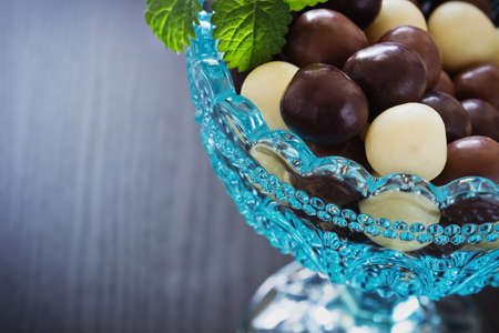 chocolates in a glass bowl on a black wooden background. festivals and events. selective focus.close-upの写真素材