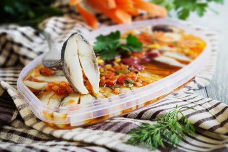 pickled herring with different vegetables on the table. cooked seafood. selective focus