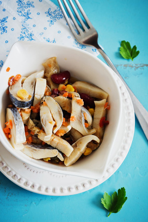 pickled herring with different vegetables in a bowl on the table. cooked seafood.top viewの写真素材