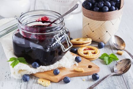 homemade blueberry jam in a jar and fresh blueberries on a table.selective focus. health and diet foodの写真素材