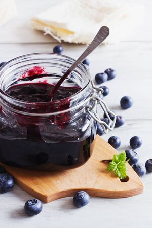 homemade blueberry jam in a jar and fresh blueberries on a table.selective focus. health and diet foodの写真素材