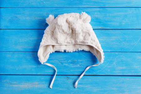 children's winter hat on a blue wooden background. baby clothesの写真素材