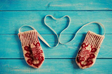 children's knitted mittens on a blue wooden background. image is tintedの写真素材