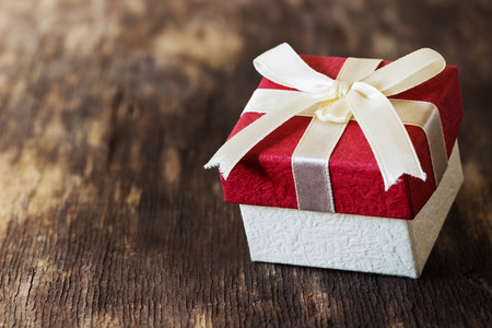 Christmas gift box with a bow on the old wooden background