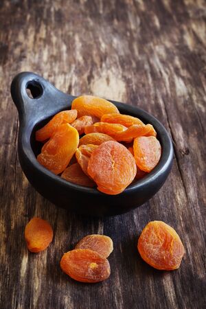 dried apricots in a bowl on a vintage wooden background. health and diet foodの写真素材