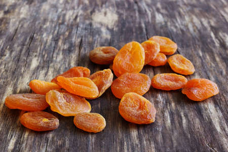 dried apricots scattered on vintage wooden background. selective focus. health and diet foodの写真素材