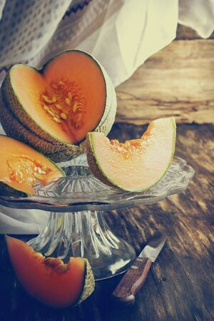 ripe melon slices on old wooden table. health and diet concept. selective focus. toned imageの写真素材