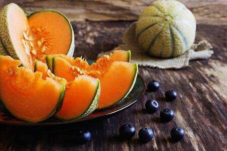 ripe melon slices on old wooden table. health and diet concept. selective focusの写真素材
