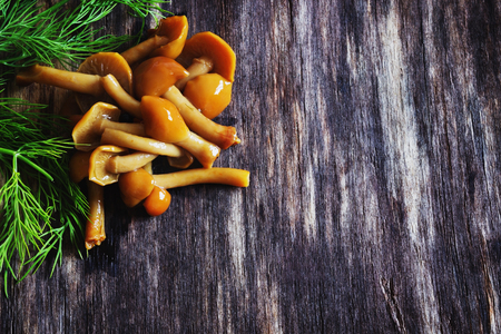 marinated mushrooms on the old wooden background. copy space backgroundの写真素材
