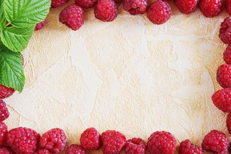 ripe juicy raspberries on a yellow background. from his garden berries. fruit background. top view....