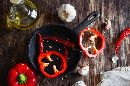 Different kinds of sweet and hot peppers, garlic and seasoning prepared for cooking meals. View from...