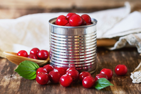 Fresh ripe cherries in a metal tin can on rustic wooden table. Preservation of products concept . Bio healthy food. Organic fruits. Selective focusの写真素材