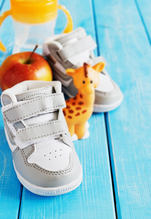 Children's sneakers gray for outdoor walking on a wooden background. Children's shoes and accessories for a walk concept.  Selective focusの写真素材