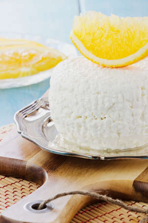 Traditional homemade cottage cheese in a plate on the table. Helpful dairy products. Selective focusの写真素材