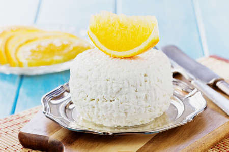 Traditional homemade cottage cheese in a plate on the table. Helpful dairy products. Selective focusの写真素材