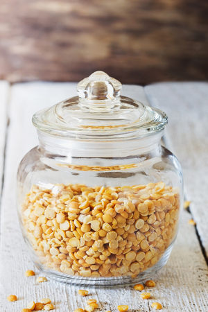 Dry peas in a glass jar on a white wooden table. Bio healthy and diet food. Selective focusの写真素材