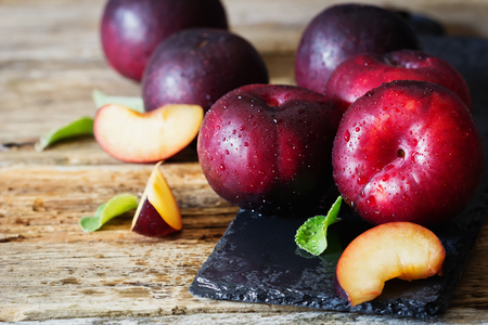 Ripe organic plums on a vintage table. Rustic style. Health and diet food .  Selective focusの写真素材