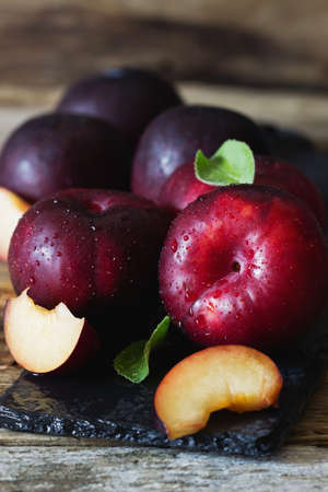 Ripe organic plums on a vintage table. Rustic style. Health and diet food .  Selective focusの写真素材