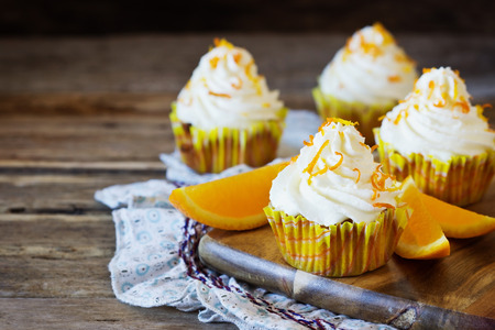Delicious homemade cupcakes and oranges on the wooden background. Selective focusの写真素材