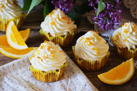Delicious homemade cupcakes and oranges on the wooden background. Selective focusの写真素材