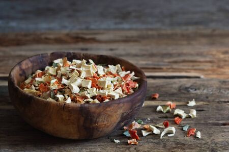 Dry chopped vegetables in a wooden bowl on the table. Spices and seasonings. Selective focusの写真素材
