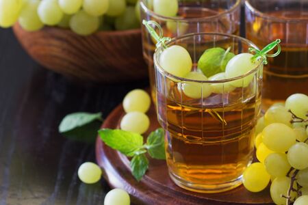 Grape juice in a glass and fresh grapes on a wooden background. Healthy eatingの写真素材