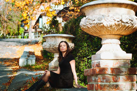 Autumn portrait of young woman in black dress in the city