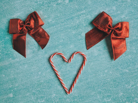 Festive blue background. Heart of sweet candies. Red bow. Winter postcard. Christmas card. Valentine...