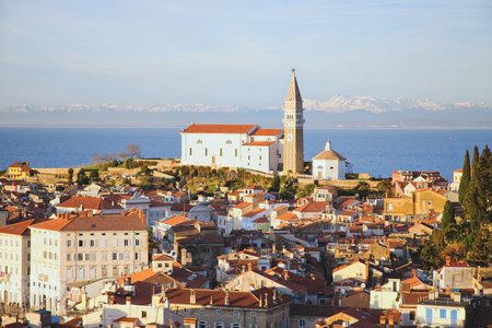 Red roofs of the historical center of old town Piran with main church against the sunset sky and Adriatic sea. Aerial view, Sloveniaの写真素材