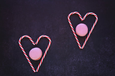 Festive dark background. Hearts of sweet candies. Colorful macaroons. Christmas card. Valentine Day....