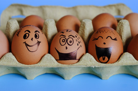 Creative Easter chicken eggs with doodle faces wearing medical masks and toy rabbit on blue...