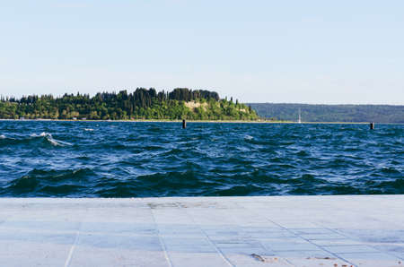 Picturesque seaside resort town in Slovenian coast against orange blue sky in summer. Scenic view to...