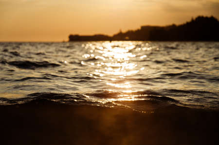 Picturesque seaside resort town in Slovenian coast against orange sunset sky in summer. Scenic view...