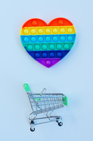 Top view of colorful anti stress sensory toy pop it rainbow heart on blue background close up. Creative and funny concepts of children toys. Popular toy. Trend toy 2021 year.の写真素材