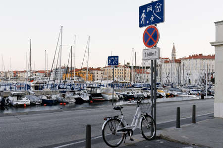 Scenic view of narrow empty streets of historical center of old town Piran against the sunrise sky and Adriatic sea with yachts. Summer vacation to coast of Slovenia.のeditorial素材